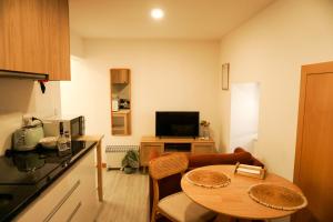 a small living room with a table and a kitchen at VIELA Guest House T1 in Barcelos