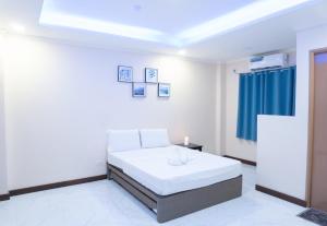 a white room with a bed and a blue curtain at Balud White Beach Resort in Moalboal +16 photos