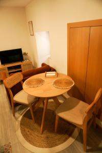 a living room with a wooden table and chairs at VIELA Guest House T1 in Barcelos