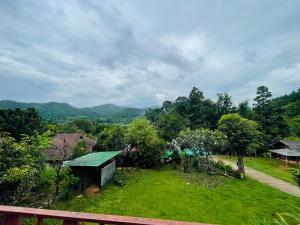 a view of a garden with mountains in the background at Forest Fishing in Ban Pa Kluai