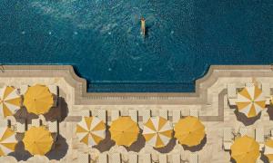 an overhead view of a swimming pool with umbrellas at COMO Le Beauvallon - Golfe de Saint-Tropez in Grimaud