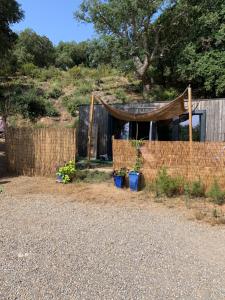 a fence with a tent in a yard at Châlet de charme in Taillet