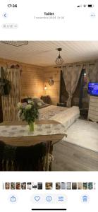 a bedroom with a bed and a table with a vase at Châlet de charme in Taillet
