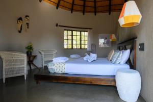 a bedroom with a large bed and a window at Mbizi Bush Lodge in Grietjie Game Reserve +148 photos
