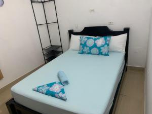 a bed with blue and white pillows on it at Hostal Monte Verde in Zaragoza