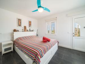 a white bedroom with a bed and a ceiling fan at Villa Sa Blanca by Interhome in Es Mercadal