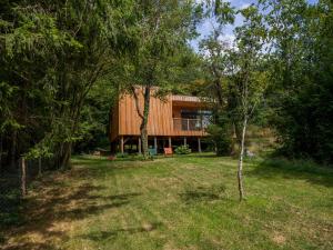 a house in the middle of a yard with trees at Chez Oreste - Escapade à 2 avec sauna et jardin clos in Aywaille