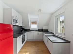 a kitchen with white cabinets and a red refrigerator at Apartment Laura - S7 by Interhome in Endingen