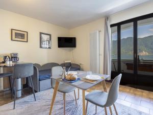 a living room with a table and chairs and a couch at Apartment Leonard Lake by Interhome in Ghiffa