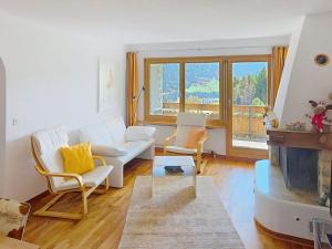 a living room with a white couch and a fireplace at Apartment Toissa A6 by Interhome in Salouf