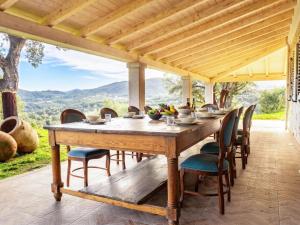 a wooden table and chairs on a patio with a view at Villa S'Olioni by Interhome in Loceri