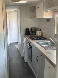 a kitchen with a sink and a stove top oven at Gunthorpe Mobile Home in East Bridgford +2 photos