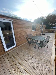 a patio with a table and chairs on a deck at Gunthorpe Mobile Home in East Bridgford