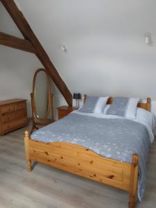 a bedroom with a wooden bed and a mirror at Le gîte de L'Étable in Magny-le-Désert +20 photos