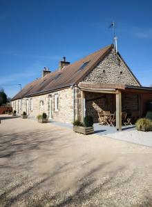a large brick building with a porch and a patio at Le gîte de L'Étable in Magny-le-Désert