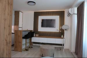 ein Wohnzimmer mit einem Fernseher an der Wand in der Unterkunft Square Studio Brcko in Brčko