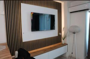 ein Flachbildfernseher an der Wand im Wohnzimmer in der Unterkunft Square Studio Brcko in Brčko
