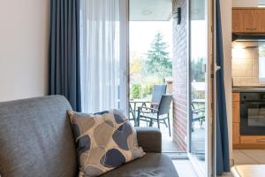 a living room with a couch and a balcony at Haus Roland, Wohnung 03 in Zinnowitz