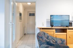 a living room with a television and a chair at Haus Roland, Wohnung 03 in Zinnowitz