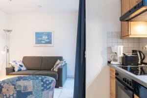 a kitchen and a living room with a couch at Haus Roland, Wohnung 03 in Zinnowitz