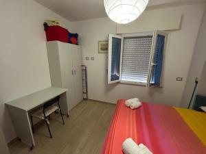 a bedroom with a bed and a desk and a window at Il Cenerone in Pineto
