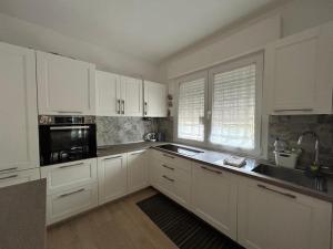 a white kitchen with white cabinets and a sink at Il Cenerone in Pineto