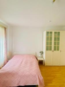 a bedroom with a pink bed and a cabinet at Dinkelsbühl-Ferienappartement in Mönchsroth