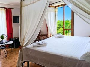 a bedroom with a white bed with a window at Hotel Residence Sant'Uberto in Roccastrada