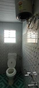 a bathroom with a toilet and a window at Wang Homestay in Sukhia Pokhari