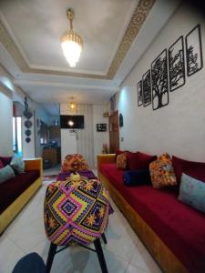 a living room with two couches and a table at Apprt Ennakhil 3 in El Jadida