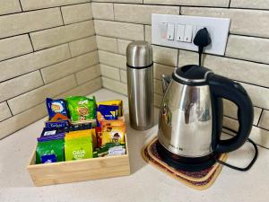a tea kettle and a box of snacks on a counter at Haritham Heritage Villa - Rooms in Vadakkāncheri