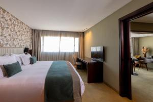 a hotel room with a large bed and a desk at Idou Anfa Hôtel & Spa in Casablanca