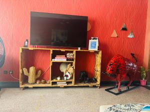 a entertainment center with a television on a red wall at Le belvédère in Casablanca