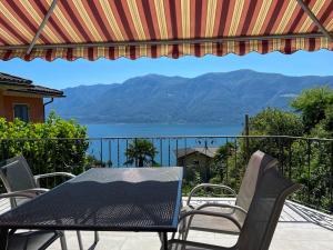 a table and chairs on a balcony with a view of the water at Molino Vecchio in Ronco sopra Ascona +15 photos