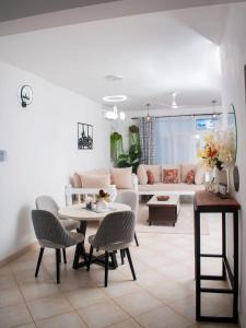 a living room with a couch and a table and chairs at Vista del mar homes in Malindi