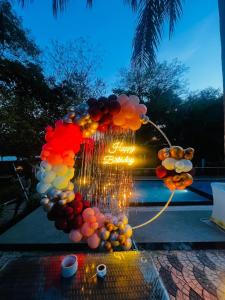 a bunch of balloons on a table with a sign at The Whispering Palms Resort in Bhopal