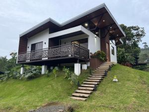 a house on a hill with a balcony and stairs at Pies descalzos in Upala