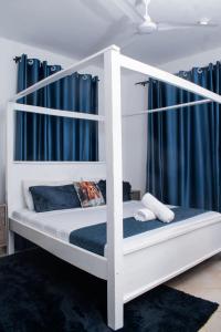 a white bunk bed in a room with blue curtains at Vista del mar homes in Malindi