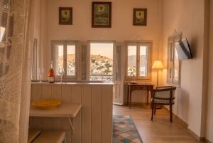 a kitchen with a counter and a desk with a window at Symi Aerides Suites in Symi