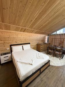 a bedroom with a bed and a wooden ceiling at FlowerHouse in Karakol