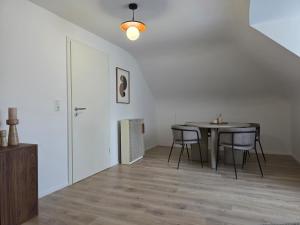 a dining room with a table and chairs at Design-Dachgeschosswohnung am Schwarzwald in Pforzheim +5 photos