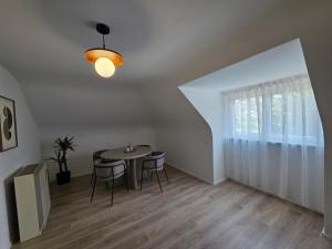 a dining room with a table and chairs and a window at Design-Dachgeschosswohnung am Schwarzwald in Pforzheim