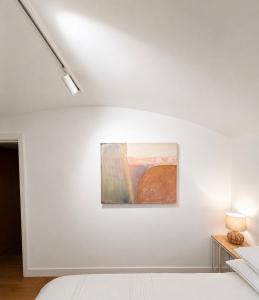a white bedroom with a painting on the wall at The Old Pub Wiltshire A Unique Luxury Cellar Retreat with Private Sauna Gym and Movie Room in Patney