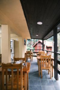 a restaurant with wooden tables and wooden chairs at Villa di Serra by Concavus in Monte Verde