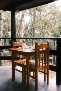 a wooden table and chairs sitting on a porch at Villa di Serra by Concavus in Monte Verde +54 photos