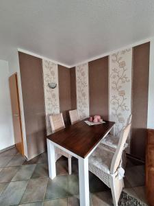 a dining room with a wooden table and chairs at Mövennest in Berumbur