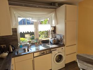 a kitchen with a sink and a washing machine at Mövennest in Berumbur +16 photos