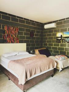 a bedroom with a bed and a brick wall at Chalés do quintal da chapada in Palmeiras +67 photos