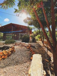 a building with a tree and a stone path at Chalés do quintal da chapada in Palmeiras