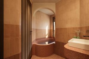 a bathroom with a bath tub and a sink at LeCloud Dalat Hotel in Khu Chi Lăng
